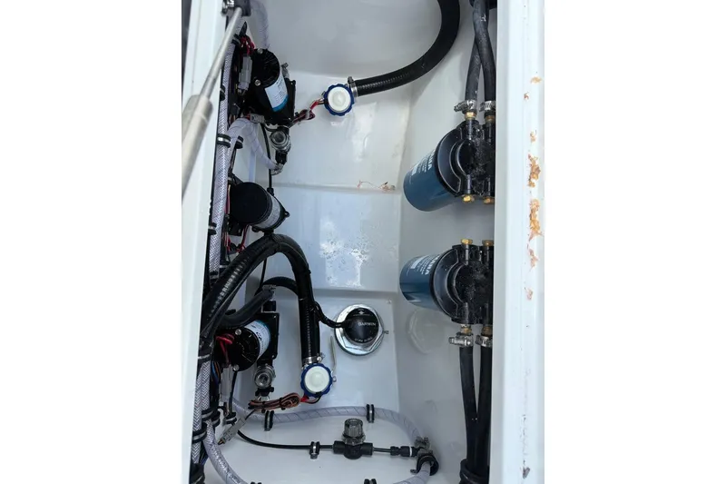 Slide: The Image of Engine compartment of 2026 Sea Hunt Gamefish 27, showcasing pumps and filters. - 23
