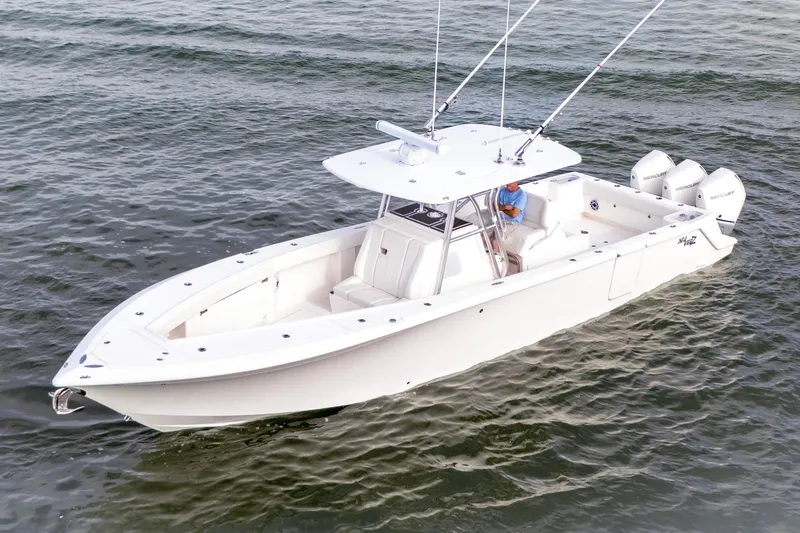 The Image of 2022 SeaVee 370Z boat cruising on open water with triple outboard engines. - 1