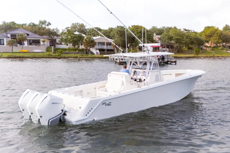 Slide: The Image of 2022 SeaVee 370Z boat with triple Mercury engines on a scenic waterway. - 15