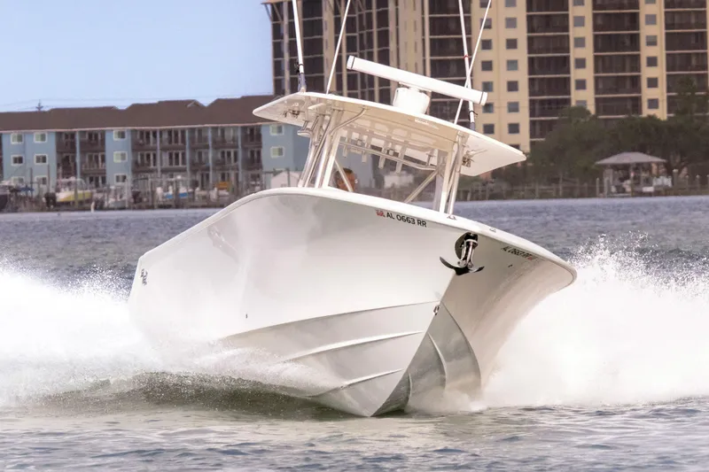 Slide: The Image of 2022 SeaVee 370Z boat cruising on water with buildings in the background. - 2