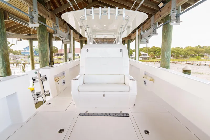Slide: The Image of 2022 SeaVee 370Z boat interior under dock, featuring seating and fishing rod holders. - 25