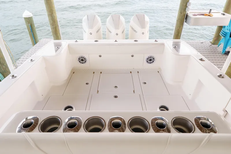 Slide: The Image of 2022 SeaVee 370Z boat deck with rod holders and triple Mercury engines. - 30