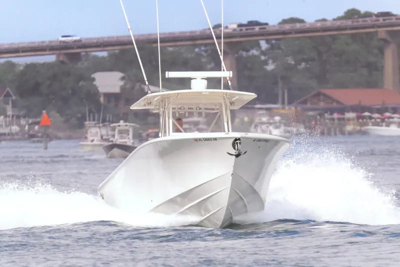 Slide: The Image of 2022 SeaVee 370Z boat cruising on water near a bridge and shoreline. - 5