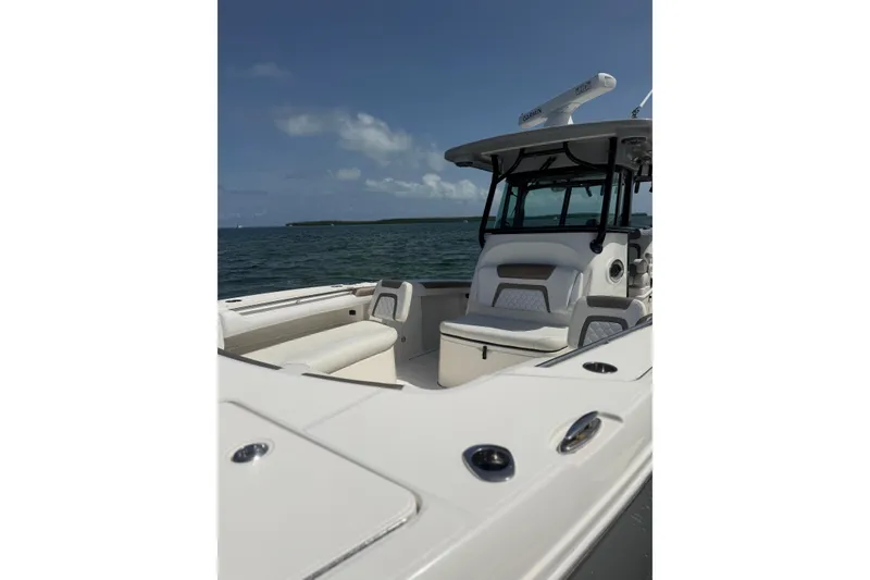 Slide: The Image of 2020 World Cat 325 CC boat on water, showcasing spacious seating and sleek design. - 14