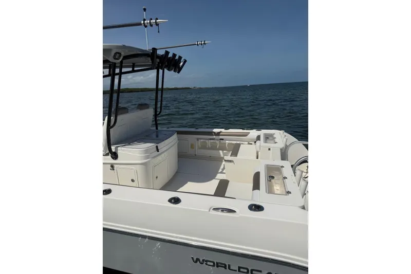 Slide: The Image of 2020 World Cat 325 CC boat on water, showcasing spacious deck and fishing rod holders. - 15