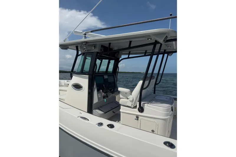Slide: The Image of 2020 World Cat 325 CC boat with sleek design, ocean backdrop, and modern helm station. - 17