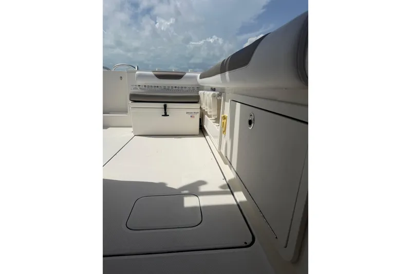 Slide: The Image of 2020 World Cat 325 CC boat interior with storage compartments and seating under a cloudy sky. - 28