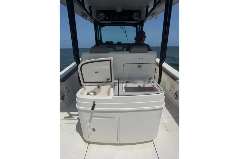 Slide: The Image of 2020 World Cat 325 CC boat interior with open storage compartment and ocean view. - 30