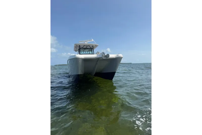 Slide: The Image of 2020 World Cat 325 CC boat on calm ocean waters under clear blue sky. - 38