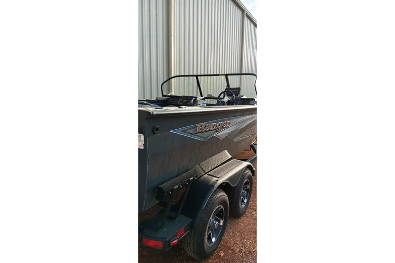 Slide: The Image of 2025 Ranger VX1788 WT boat on trailer, parked near metal building. - 5