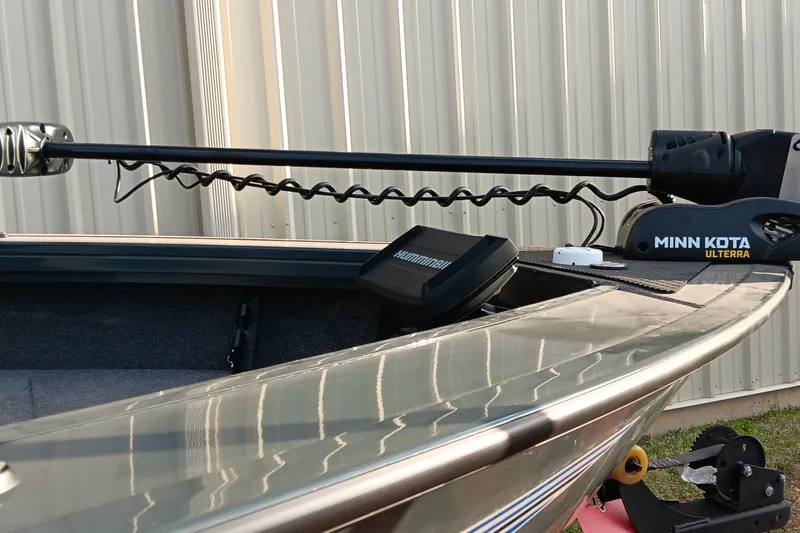 Slide: The Image of 2025 Ranger VX1788 WT boat with Minn Kota Ulterra trolling motor, docked near a metal building. - 8