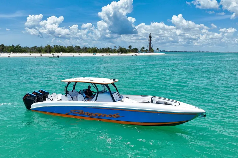 Slide: The Image of 2027 Renegade 38' Open boat cruising in turquoise waters near a sandy beach. - 18