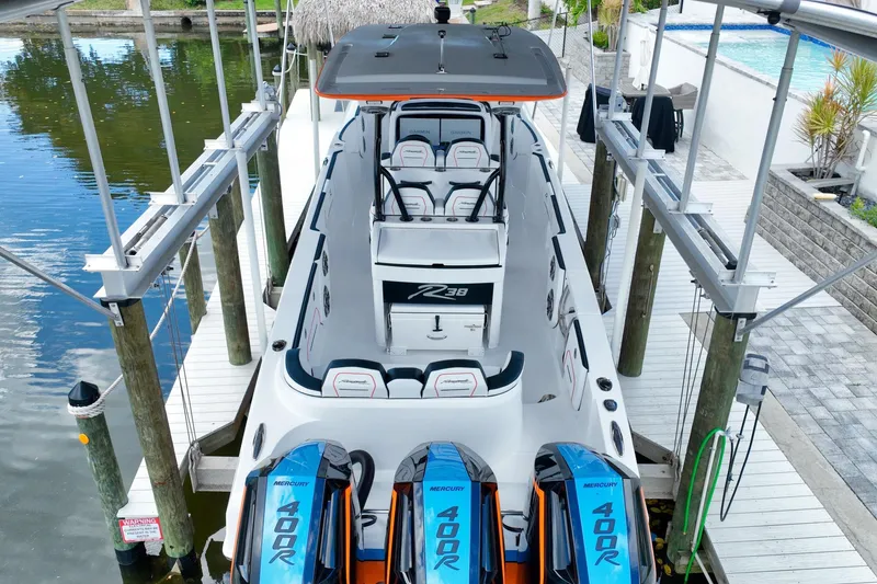 Slide: The Image of 2027 Renegade 38' Open boat with triple Mercury 400R engines docked by the water. - 2