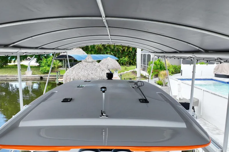 Slide: The Image of 2027 Renegade 38' Open boat under canopy near waterfront and tropical landscaping. - 3