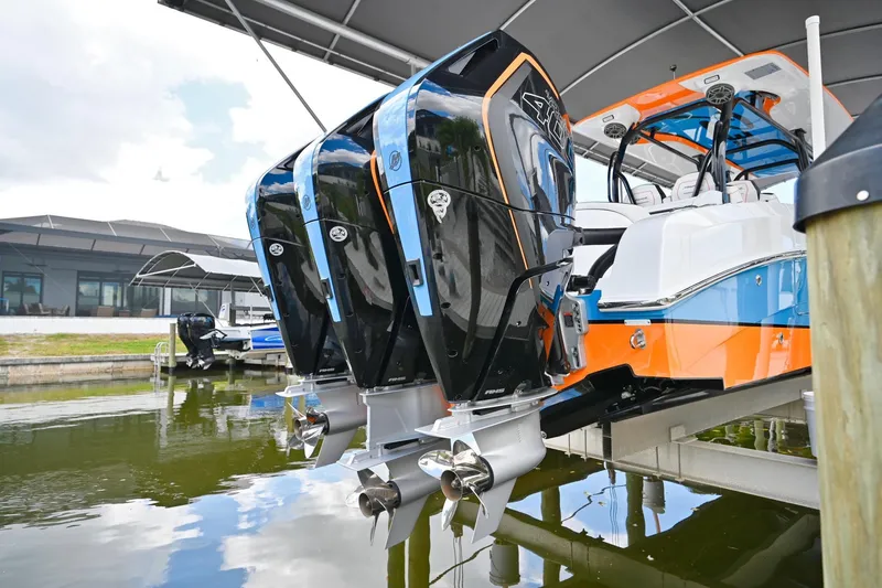Slide: The Image of 2027 Renegade 38' Open boat with triple outboard engines docked under a canopy. - 7