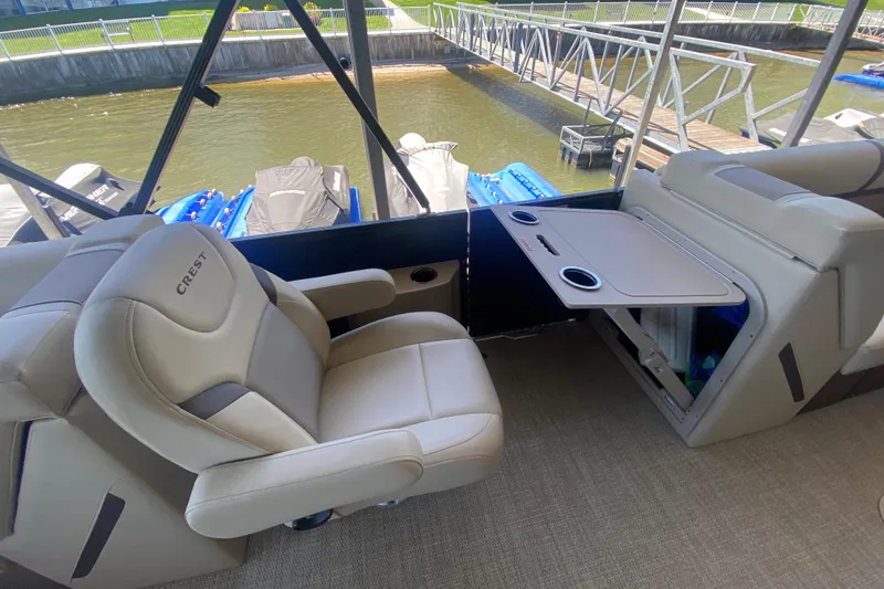 Slide: The Image of Luxurious seating on 2023 Crest Classic DLX 240 SLC pontoon boat with table and cup holders. - 15