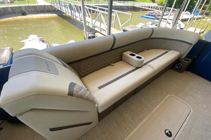 Slide: The Image of 2023 Crest Classic DLX 240 SLC pontoon boat interior with beige seating and cup holders. - 25