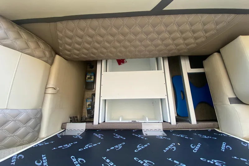 Slide: The Image of 2023 Crest Classic DLX 240 SLC boat interior storage compartments with quilted upholstery. - 27