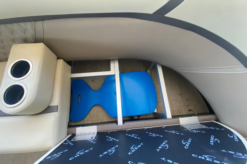 Slide: The Image of 2023 Crest Classic DLX 240 SLC interior with cup holders and storage compartment. - 28