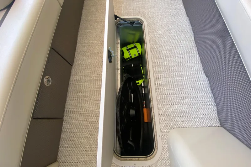 Slide: The Image of 2023 Crest Classic DLX 240 SLC boat storage compartment with safety gear and equipment. - 29