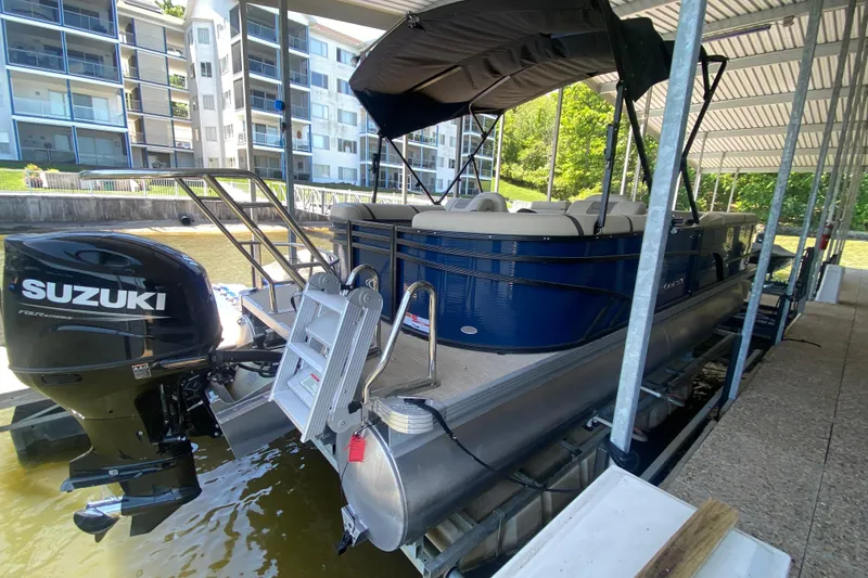 Slide: The Image of 2023 Crest Classic DLX 240 SLC pontoon boat docked with Suzuki outboard motor. - 5