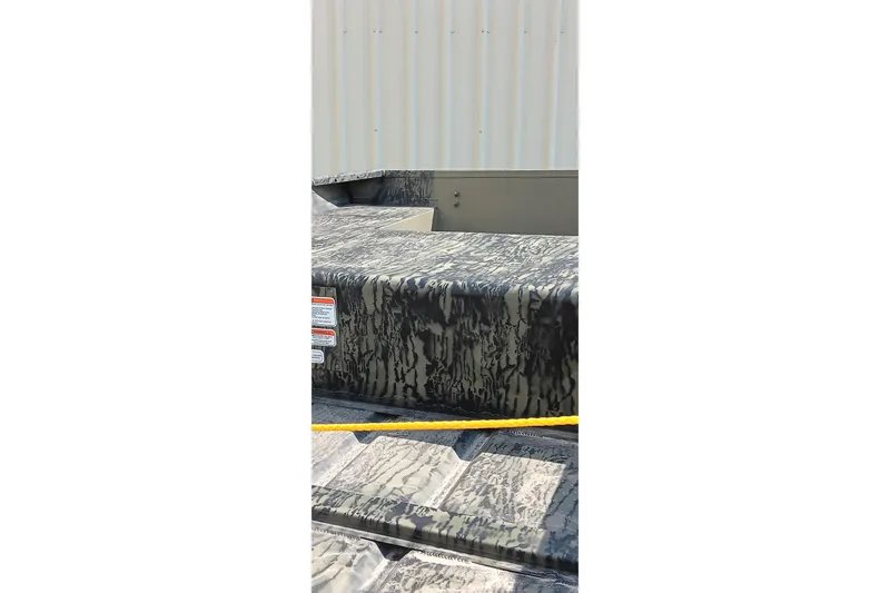 Slide: The Image of 2026 Tracker Topper 1542 LW Riveted Jon boat with camouflage pattern, outdoor setting. - 10