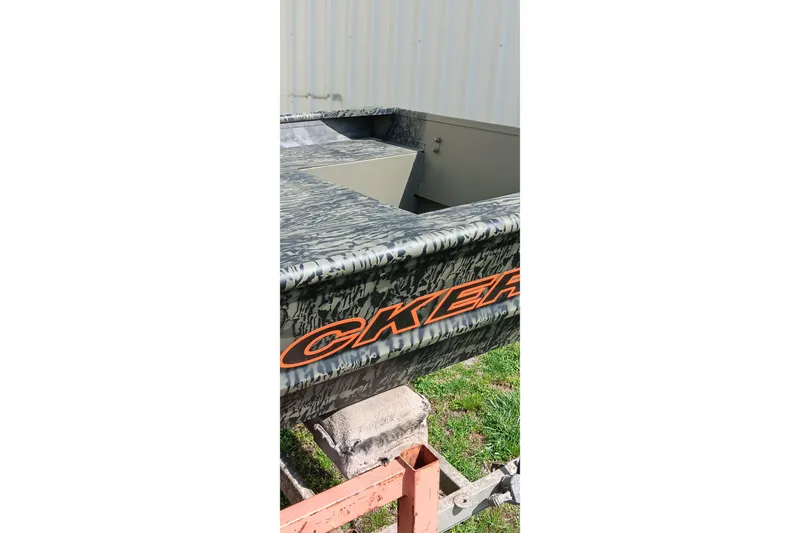 Slide: The Image of 2026 Tracker Topper 1542 LW Riveted Jon boat with camouflage design on trailer. - 13