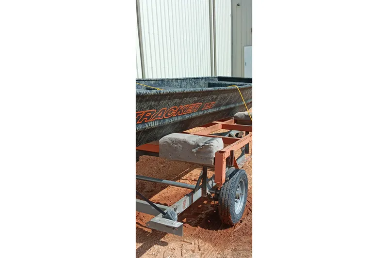 Slide: The Image of 2026 Tracker Topper 1542 LW Riveted Jon boat on trailer, parked outdoors. - 15