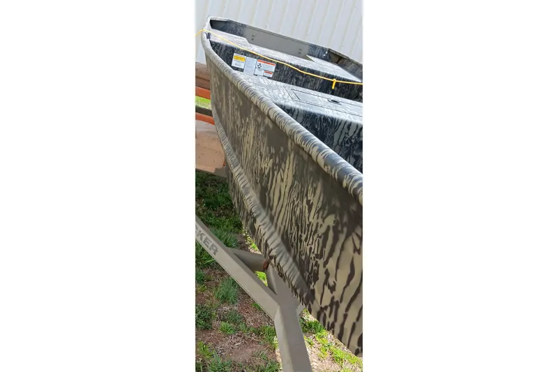 Slide: The Image of 2026 Tracker Topper 1542 LW Riveted Jon boat with camouflage pattern on display. - 8