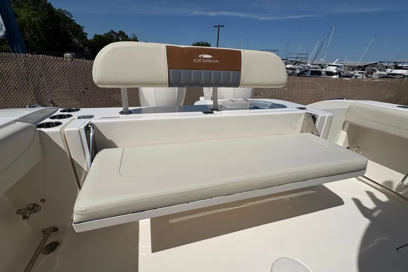 Slide: The Image of 2018 Cobia 277 Center Console boat with beige seating and cup holders. - 13