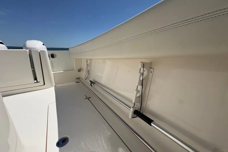 Slide: The Image of 2018 Cobia 277 Center Console boat interior with rod holders and sleek design. - 16