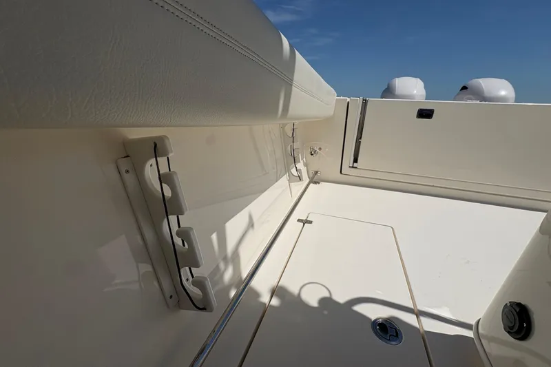 Slide: The Image of 2018 Cobia 277 Center Console boat interior with rod holders and storage compartment. - 17