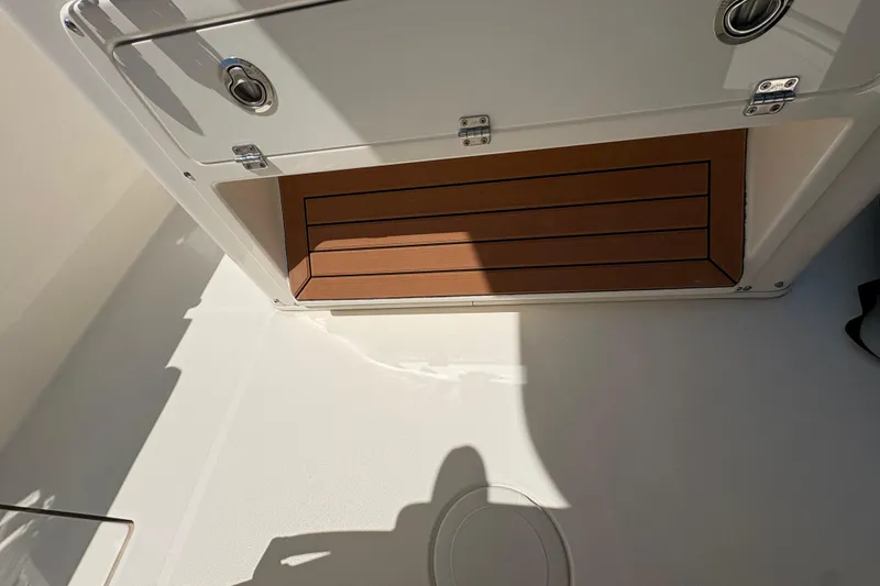 Slide: The Image of 2018 Cobia 277 Center Console boat storage compartment with wooden finish. - 18