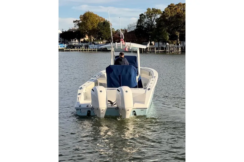 Slide: The Image of 2018 Cobia 277 Center Console boat cruising on a calm lake. - 2