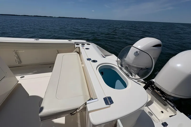 Slide: The Image of 2018 Cobia 277 Center Console boat with seating and motor, on open water. - 21