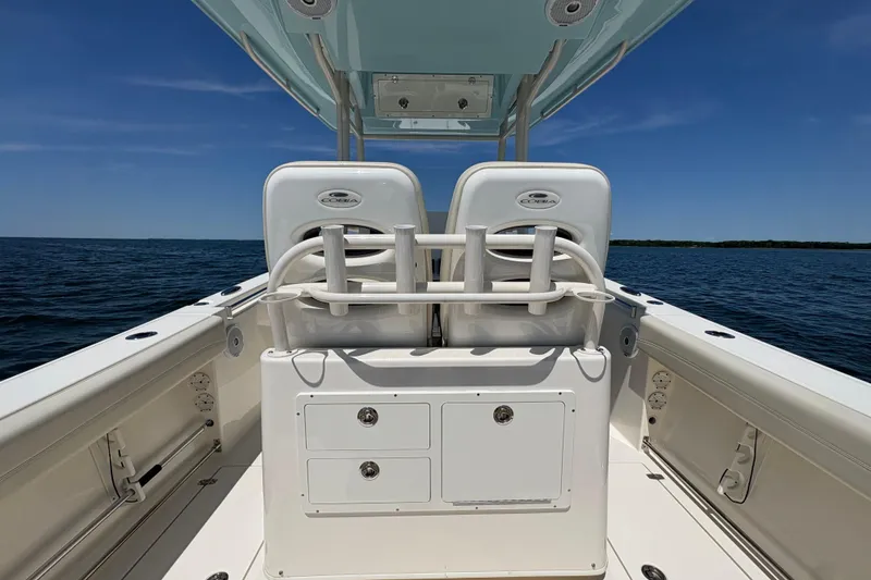 Slide: The Image of 2018 Cobia 277 Center Console boat on open water, featuring dual seats and storage. - 25