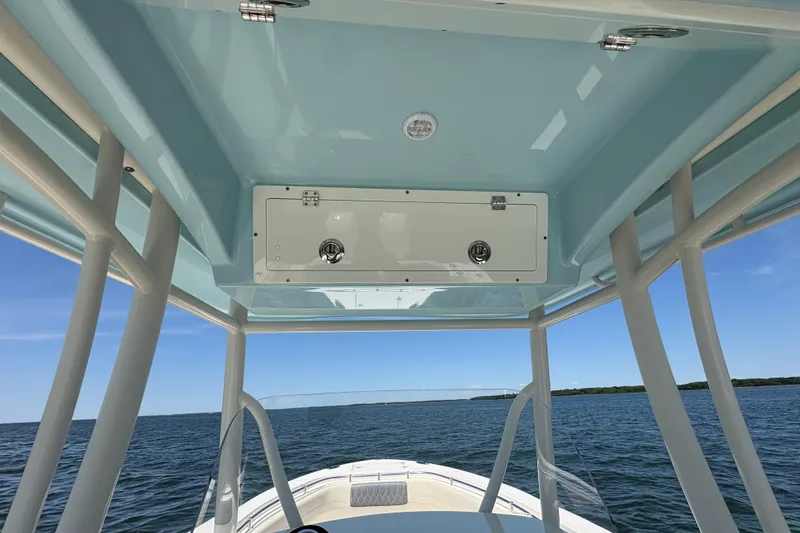 Slide: The Image of 2018 Cobia 277 Center Console boat with blue T-top on open water. - 26