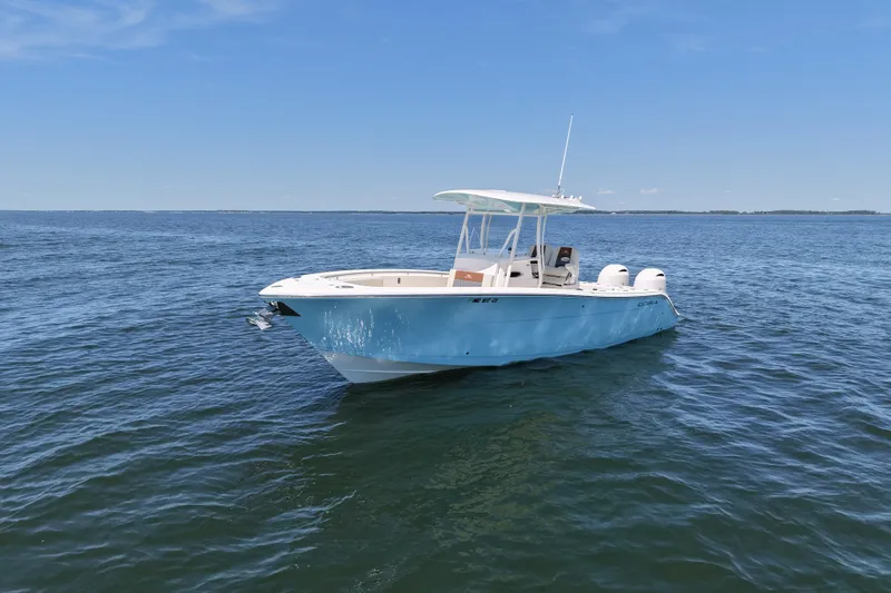 Slide: The Image of 2018 Cobia 277 Center Console boat on open water under clear blue sky. - 6