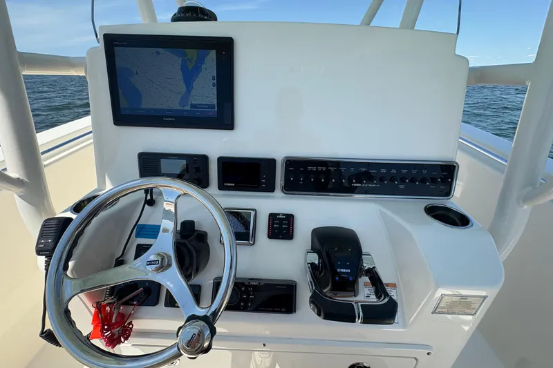 Slide: The Image of 2018 Cobia 277 Center Console dashboard with steering wheel and navigation equipment. - 8