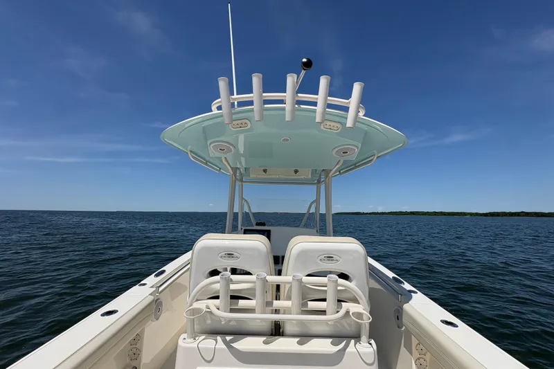 Slide: The Image of 2018 Cobia 277 Center Console boat on open water under clear blue sky. - 9