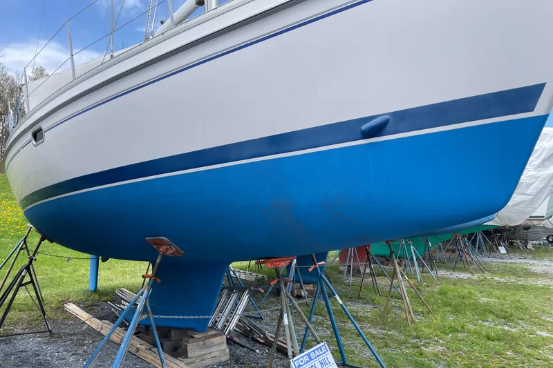 The Image of 2014 Catalina 355 sailboat on stands, blue hull, for sale sign visible. - 0