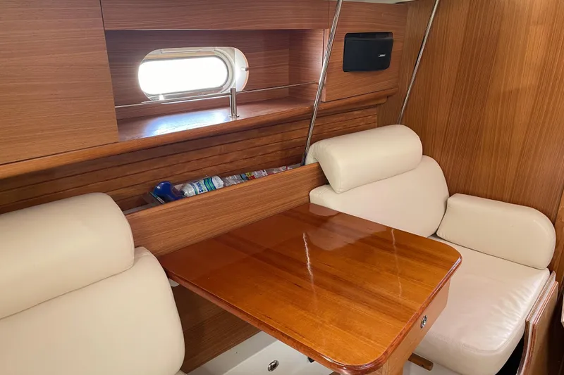 Slide: The Image of Interior of a 2014 Catalina 355 sailboat with wooden table and cream seating. - 21