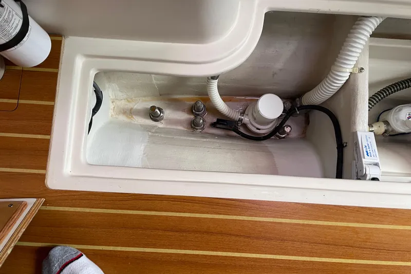 Slide: The Image of Interior view of a 2014 Catalina 355 sailboat, showcasing plumbing and wiring components. - 24
