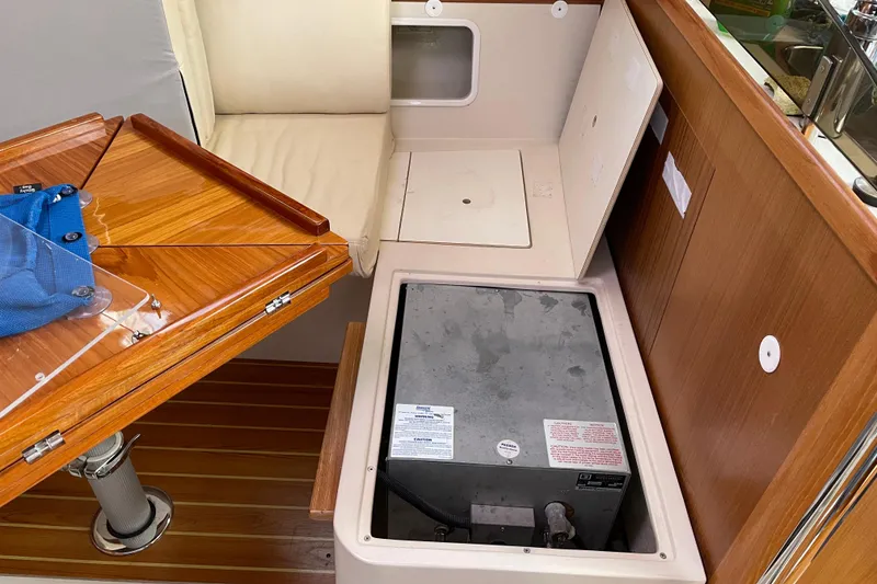 Slide: The Image of Interior of a 2014 Catalina 355 sailboat showing storage compartment and wooden table. - 26