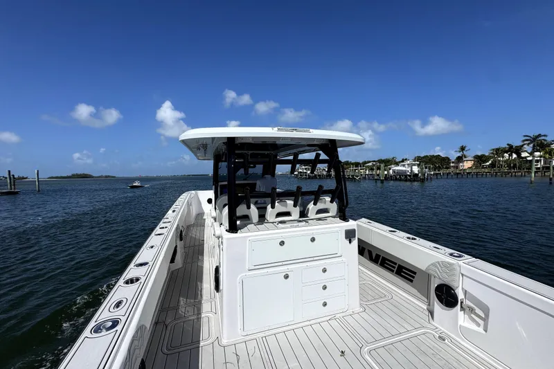 Slide: The Image of 2025 Twin Vee 400 GFX2 CC boat on calm water under clear blue sky. - 10