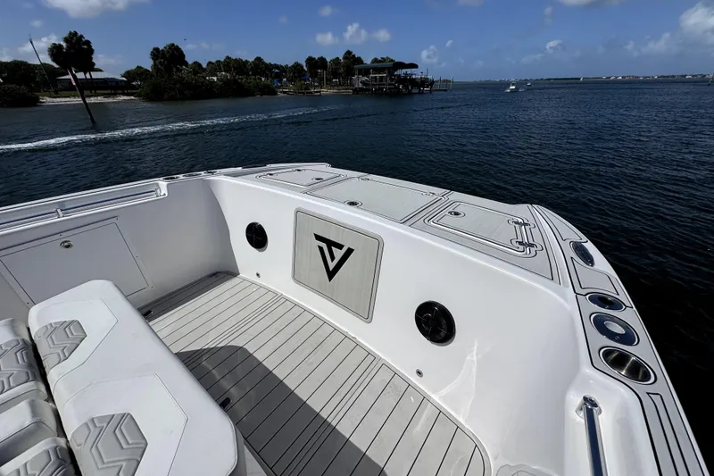 Slide: The Image of 2025 Twin Vee 400 GFX2 CC boat deck with scenic waterfront view. - 13