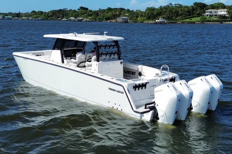 Slide: The Image of 2025 Twin Vee 400 GFX2 CC boat with quad Mercury engines on open water. - 2