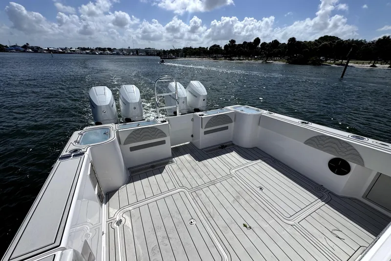 Slide: The Image of 2025 Twin Vee 400 GFX2 CC boat deck with triple engines on a sunny day. - 4
