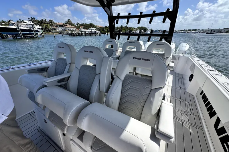 Slide: The Image of Luxury seating on 2025 Twin Vee 400 GFX2 CC boat, docked by waterfront. - 7