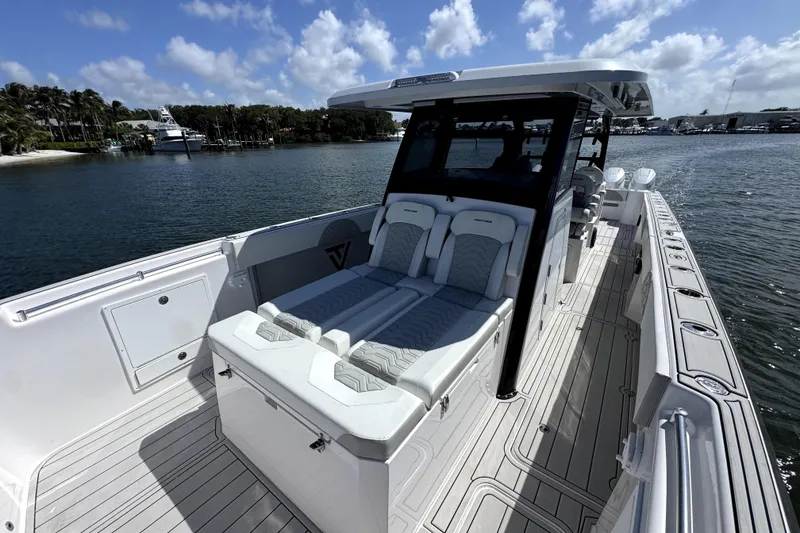 Slide: The Image of 2025 Twin Vee 400 GFX2 CC boat with sleek seating and modern design on calm water. - 8